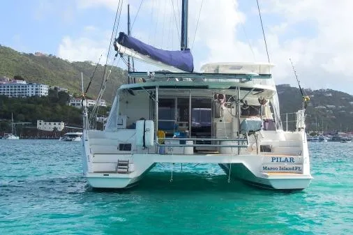 Pilar Yacht Photos Pics 2015 Robertson & Caine Leopard 48 catamaran on turquoise water, scenic coastal backdrop.