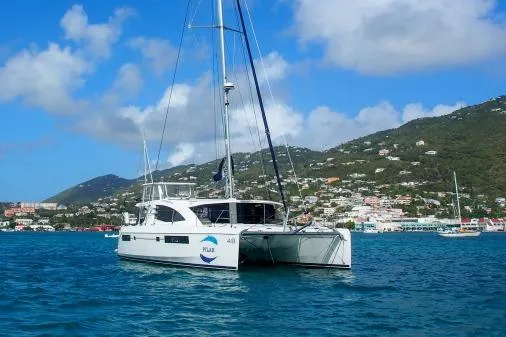 Pilar Yacht Photos Pics 2015 Robertson & Caine Leopard 48 catamaran sailing in a scenic coastal area.