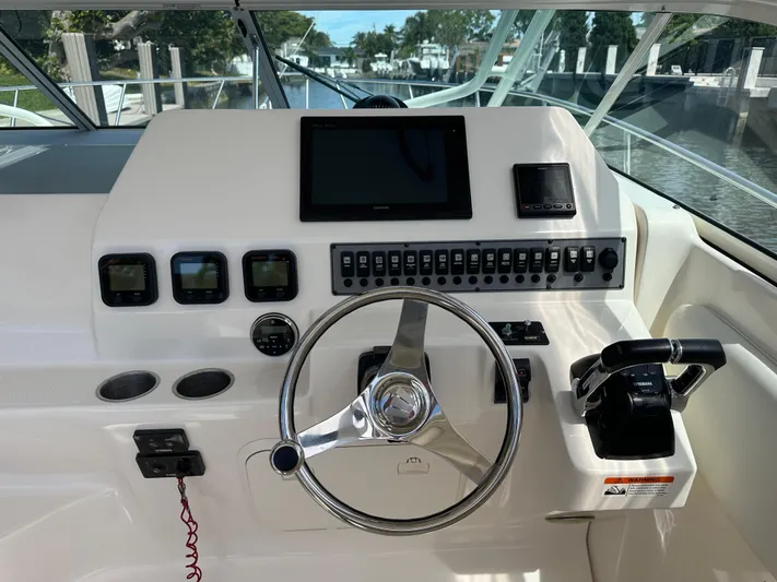 Last One II Yacht Photos Pics 2015 Wellcraft 290 Coastal helm with steering wheel, controls, and navigation display.