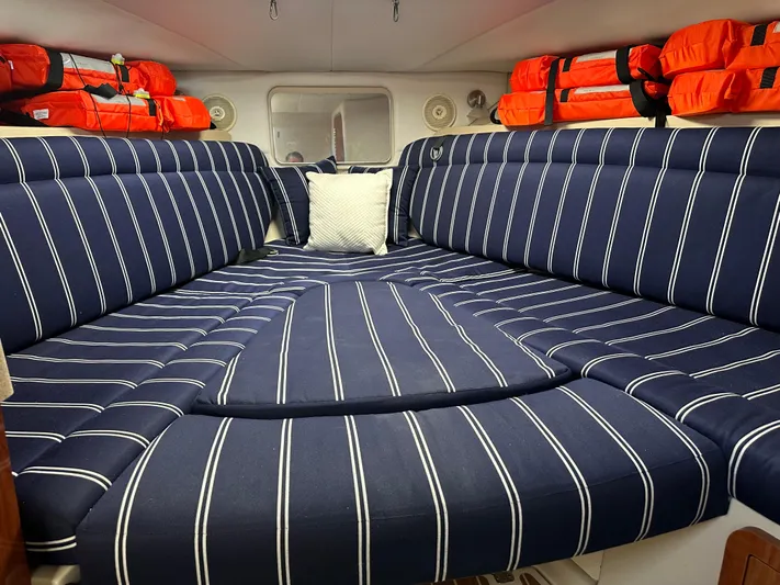 Last One II Yacht Photos Pics Interior cabin of 2015 Wellcraft 290 Coastal with striped cushions and life jackets.