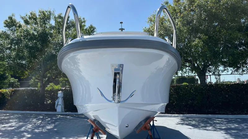In-stock 2024 Nimbus T8 #314 Yacht Photos Pics 2024 Nimbus Tender 8 #314 boat front view, displayed outdoors with trees in background.