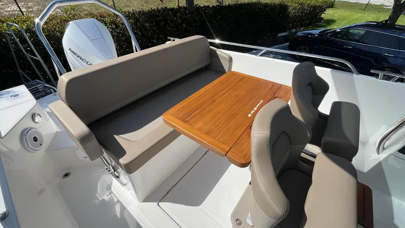 In-stock 2024 Nimbus T8 #314 Yacht Photos Pics 2024 Nimbus Tender 8 #314 boat interior with cushioned seating and wooden table.