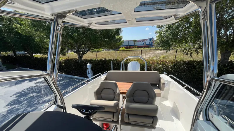 In-stock 2024 Nimbus T8 #314 Yacht Photos Pics 2024 Nimbus Tender 8 #314 boat interior with seating and canopy, parked outdoors.