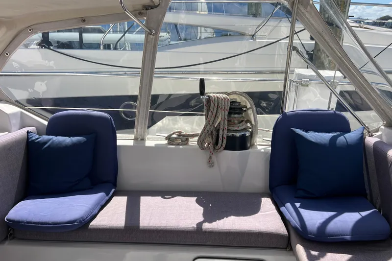 Hobo Tiempo Yacht Photos Pics Cozy seating area on 1986 Amel Mango yacht with blue cushions and nautical ropes.