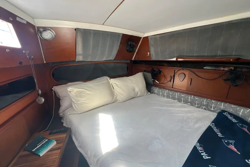 Hobo Tiempo Yacht Photos Pics Cozy cabin interior of 1986 Amel Mango sailboat with bed and nautical decor.