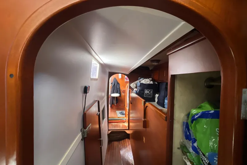 Hobo Tiempo Yacht Photos Pics Interior view of 1986 Amel Mango sailboat, featuring wooden finishes and storage areas.