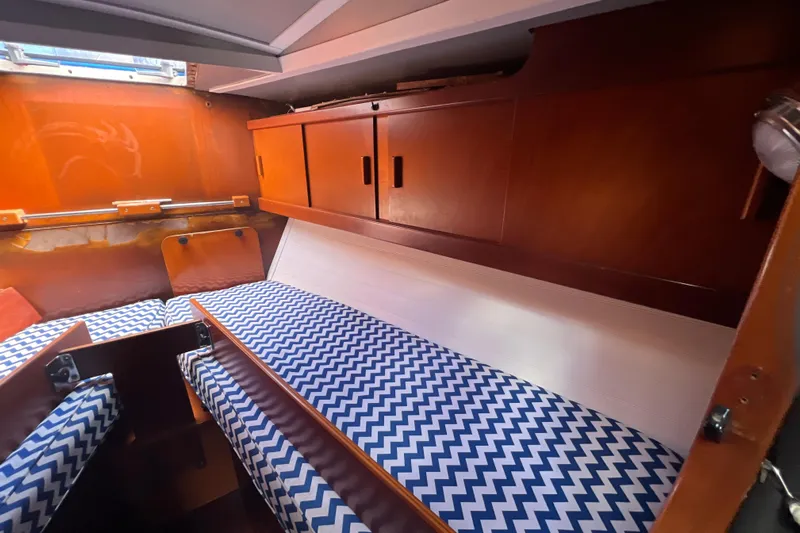 Hobo Tiempo Yacht Photos Pics Cozy cabin interior of 1986 Amel Mango sailboat with chevron-patterned cushions.