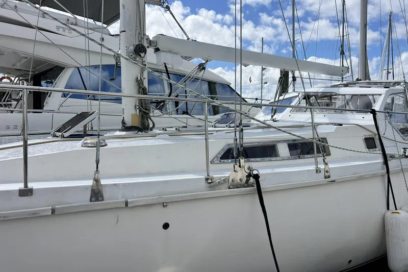 Hobo Tiempo Yacht Photos Pics 1986 Amel Mango sailboat docked at marina, surrounded by other yachts under a partly cloudy sky.