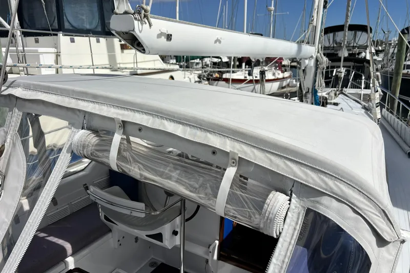 Hobo Tiempo Yacht Photos Pics 1986 Amel Mango sailboat with white canopy and marina background.