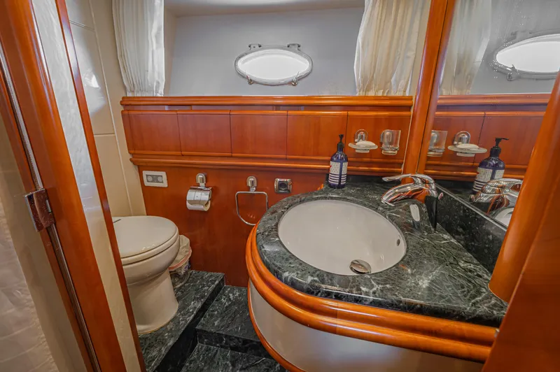 Isabella K Yacht Photos Pics Luxurious bathroom in 2002 Astondoa 72 GLX yacht with marble countertop and wooden accents.