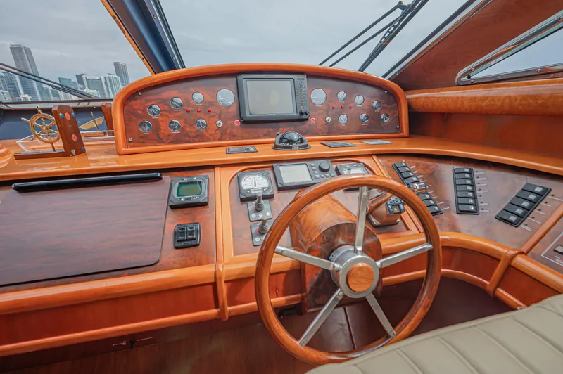 Isabella K Yacht Photos Pics Cockpit of 2002 Astondoa 72 GLX yacht with wooden steering wheel and control panel.