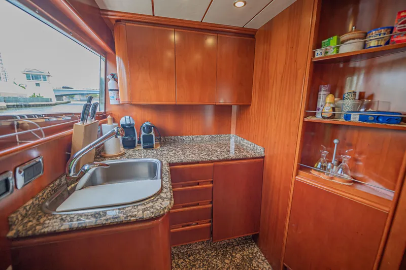 Isabella K Yacht Photos Pics Luxurious kitchen in 2002 Astondoa 72 GLX yacht with wooden cabinets and granite countertops.