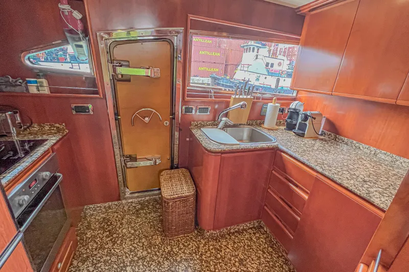 Isabella K Yacht Photos Pics Luxurious kitchen in 2002 Astondoa 72 GLX yacht with granite countertops and wooden cabinetry.