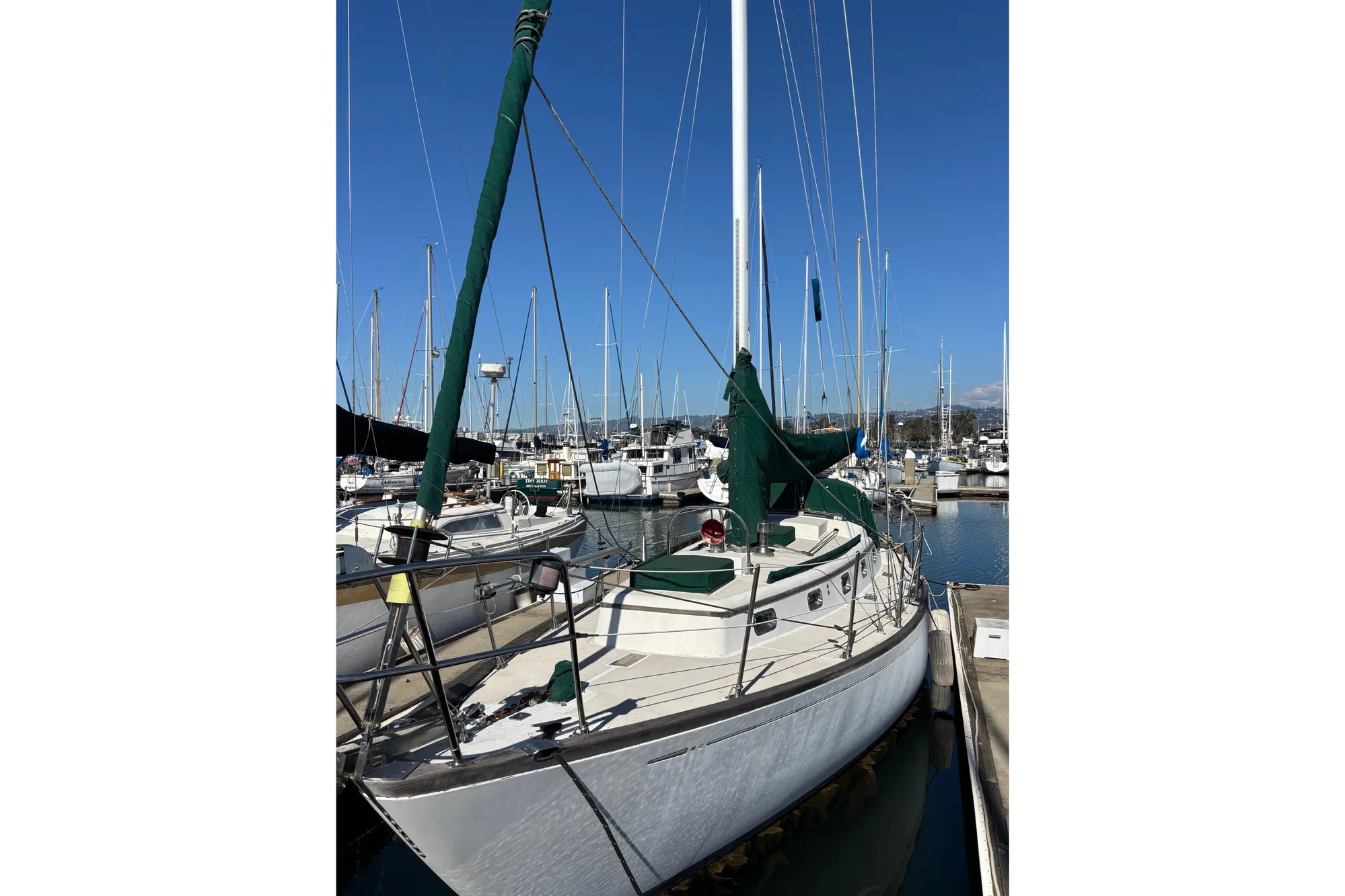 1985 Mason 33 sailboat docked in marina under clear blue sky.