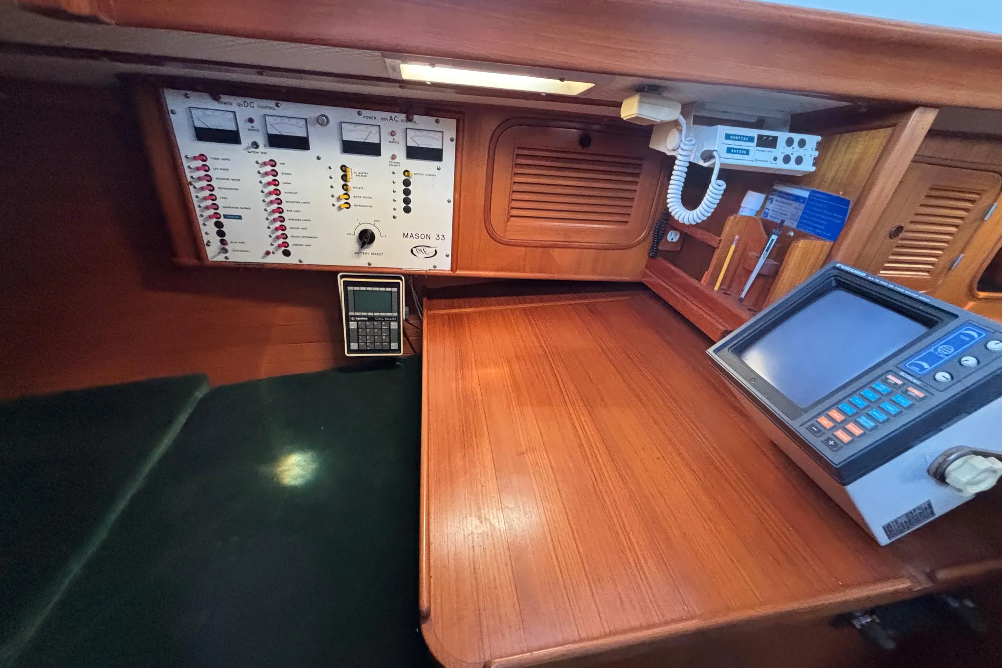 Control panel and navigation equipment inside a 1985 Mason 33 sailboat cabin.