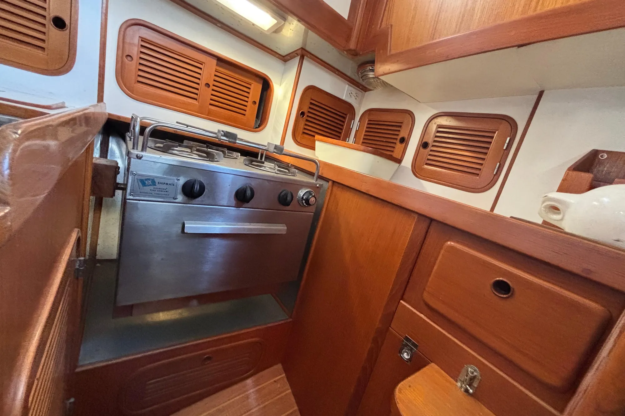 Compact wooden boat kitchen with stainless steel stove, Mason 33, 1985 model.