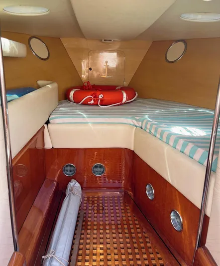 Turquoise Yacht Photos Pics Interior of a 1974 Riva Aquarama Special boat with striped bedding and life preserver.