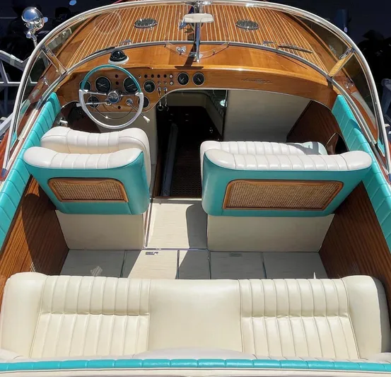 Turquoise Yacht Photos Pics 1974 Riva Aquarama Special boat interior with turquoise and cream seating, wooden dashboard, and steering wheel.