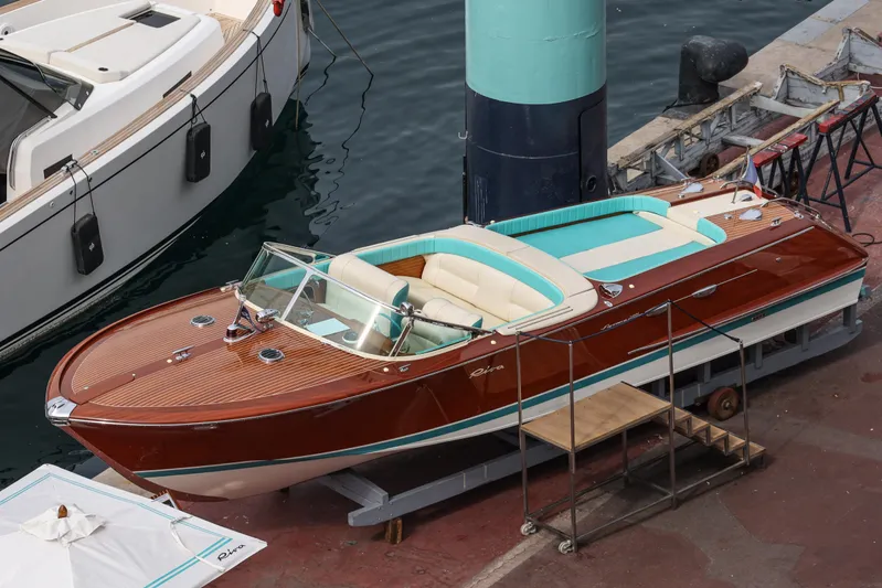Turquoise Yacht Photos Pics 1974 Riva Aquarama Special boat docked, showcasing classic wooden design and turquoise interior.