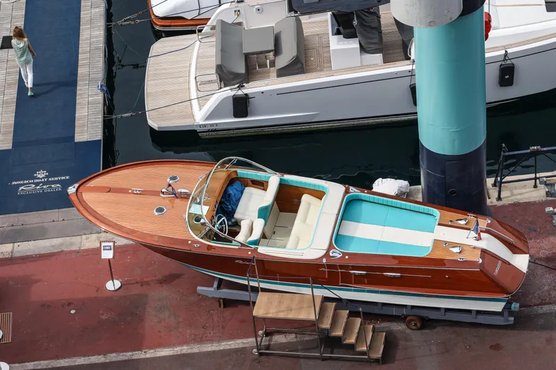 Turquoise Yacht Photos Pics 1974 Riva Aquarama Special boat docked at Monaco Boat Service, showcasing classic wooden design.