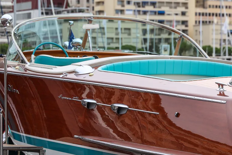 Turquoise Yacht Photos Pics 1974 Riva Aquarama Special boat with turquoise interior, docked in a marina.