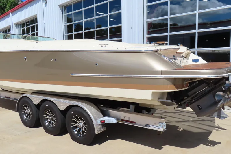  Yacht Photos Pics 2018 Chris Craft Launch 34 boat on trailer, parked outside a garage.