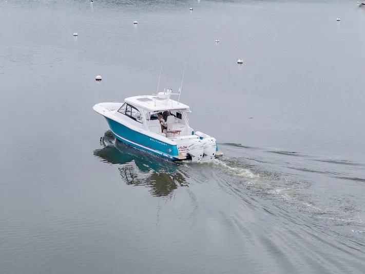 Even Flow Yacht Photos Pics 2021 Southport 33 DC boat cruising on calm water with visible wake.