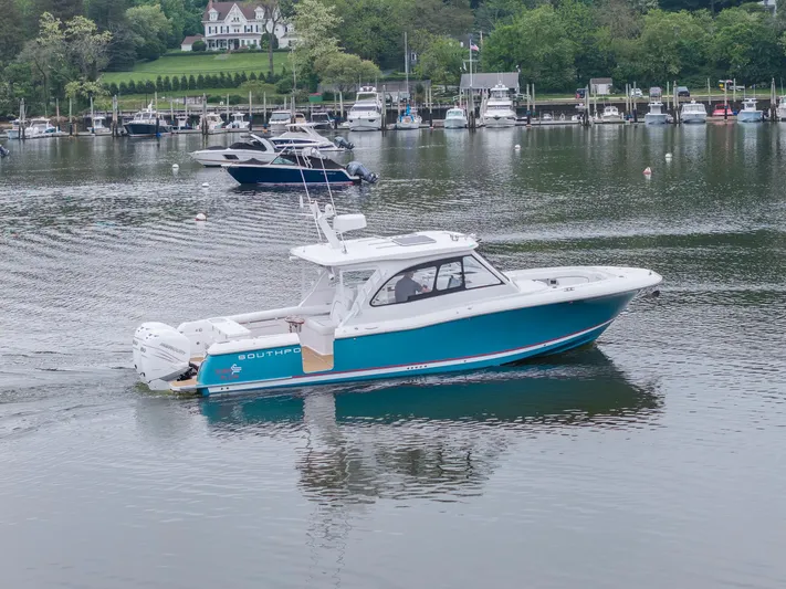 Even Flow Yacht Photos Pics 2021 Southport 33 DC boat on a calm lake with marina background.