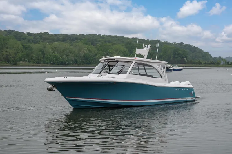 Even Flow Yacht Photos Pics 2021 Southport 33 DC boat on calm water with lush green background.