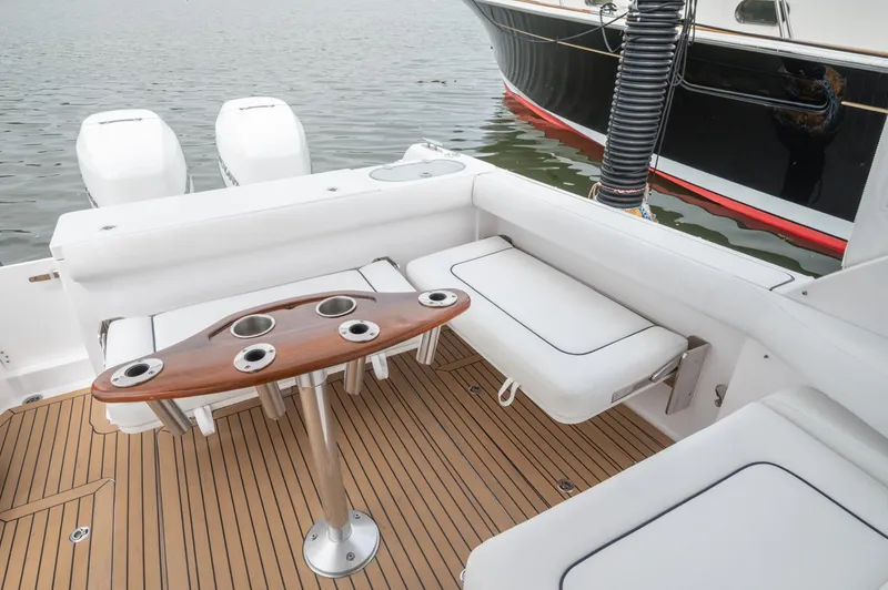 Even Flow Yacht Photos Pics 2021 Southport 33 DC boat interior with seating and wooden table on deck.