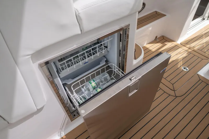 Even Flow Yacht Photos Pics Stainless steel fridge on 2021 Southport 33 DC boat with wooden deck.