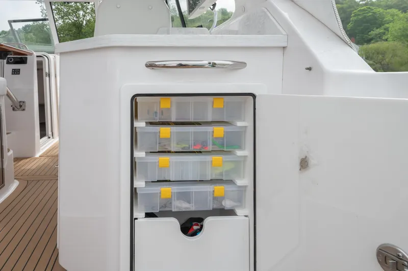 Even Flow Yacht Photos Pics 2021 Southport 33 DC boat storage compartment with organized tackle boxes.