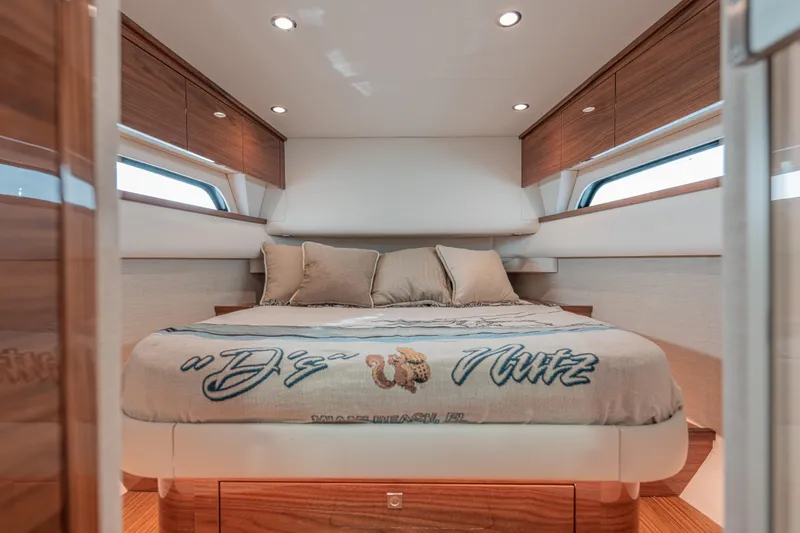  Yacht Photos Pics Luxurious cabin interior of 2024 Valhalla Boatworks V-55 with cozy bedding and wood accents.