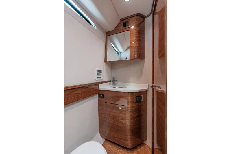  Yacht Photos Pics Luxurious 2024 Valhalla V-55 boat bathroom with wood accents and modern fixtures.