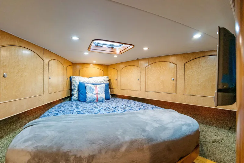 Seacario Yacht Photos Pics Cozy cabin interior of 2001 Custom Carolina Sportfish with wood paneling and bedding.