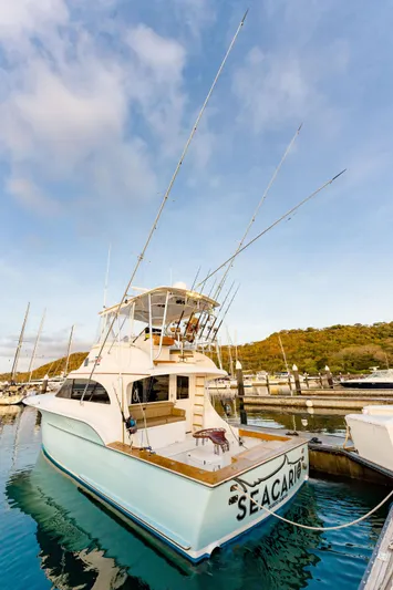 Seacario Yacht Photos Pics Custom Carolina Sportfish 2001 docked, featuring fishing rods and a spacious deck.