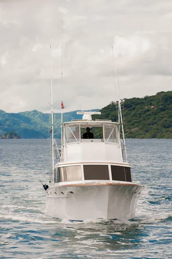 Seacario Yacht Photos Pics 2001 Custom Carolina Sportfish boat cruising on scenic waterway with lush hills.