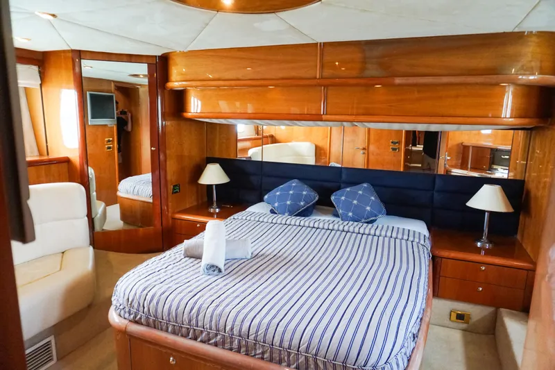 Ohana Yacht Photos Pics Luxurious bedroom interior of 2004 Sunseeker Manhattan 64 yacht with striped bedding.