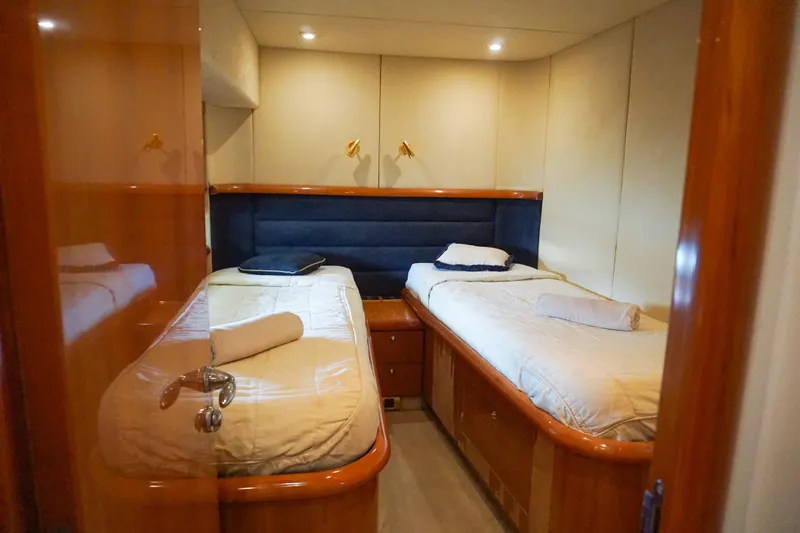 Ohana Yacht Photos Pics Twin cabin interior of 2004 Sunseeker Manhattan 64 yacht, featuring cozy beds and elegant wood finishes.