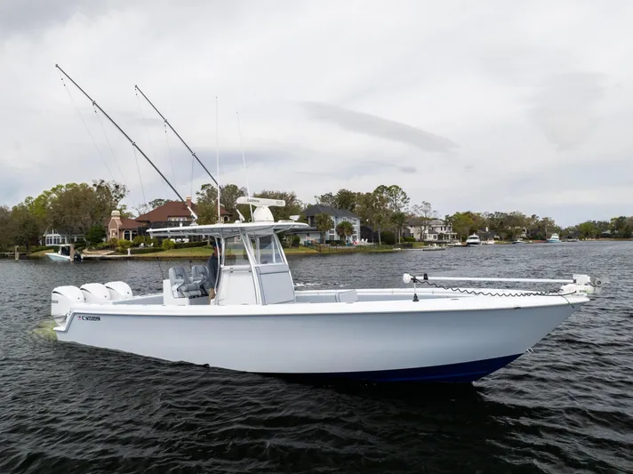  Yacht Photos Pics 2022 Contender 35 ST boat on a calm lake with scenic shoreline.