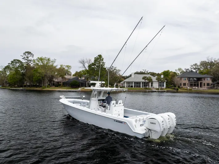  Yacht Photos Pics 2022 Contender 35 ST boat cruising on a lake with houses in the background.