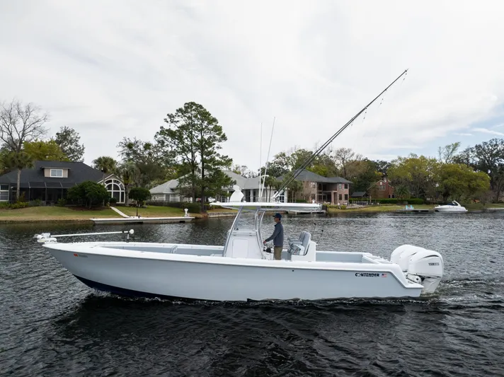  Yacht Photos Pics 2022 Contender 35 ST boat cruising on a calm lake near waterfront homes.