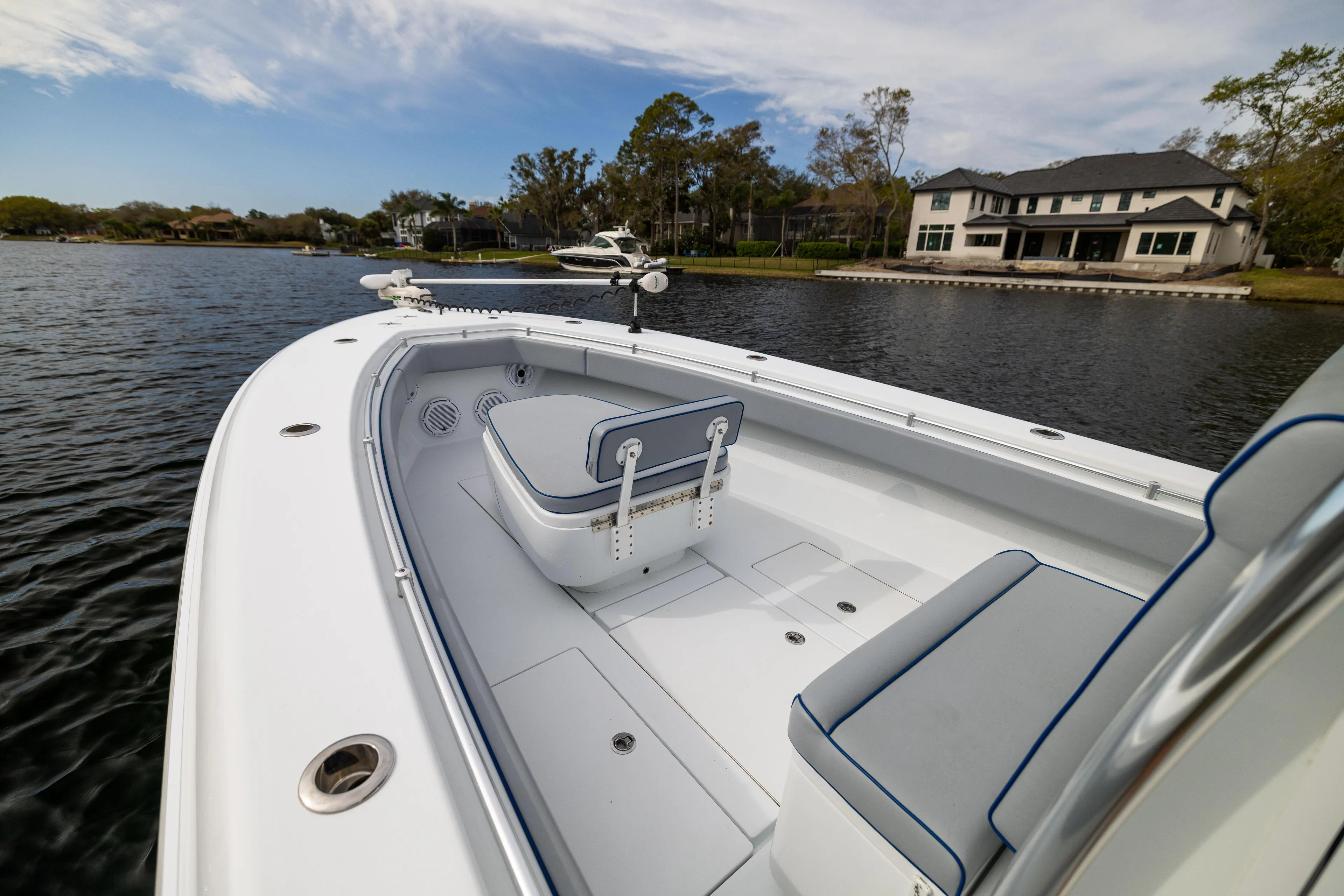  Yacht Photos Pics 2022 Contender 35 ST boat on a serene lake near a luxury home.