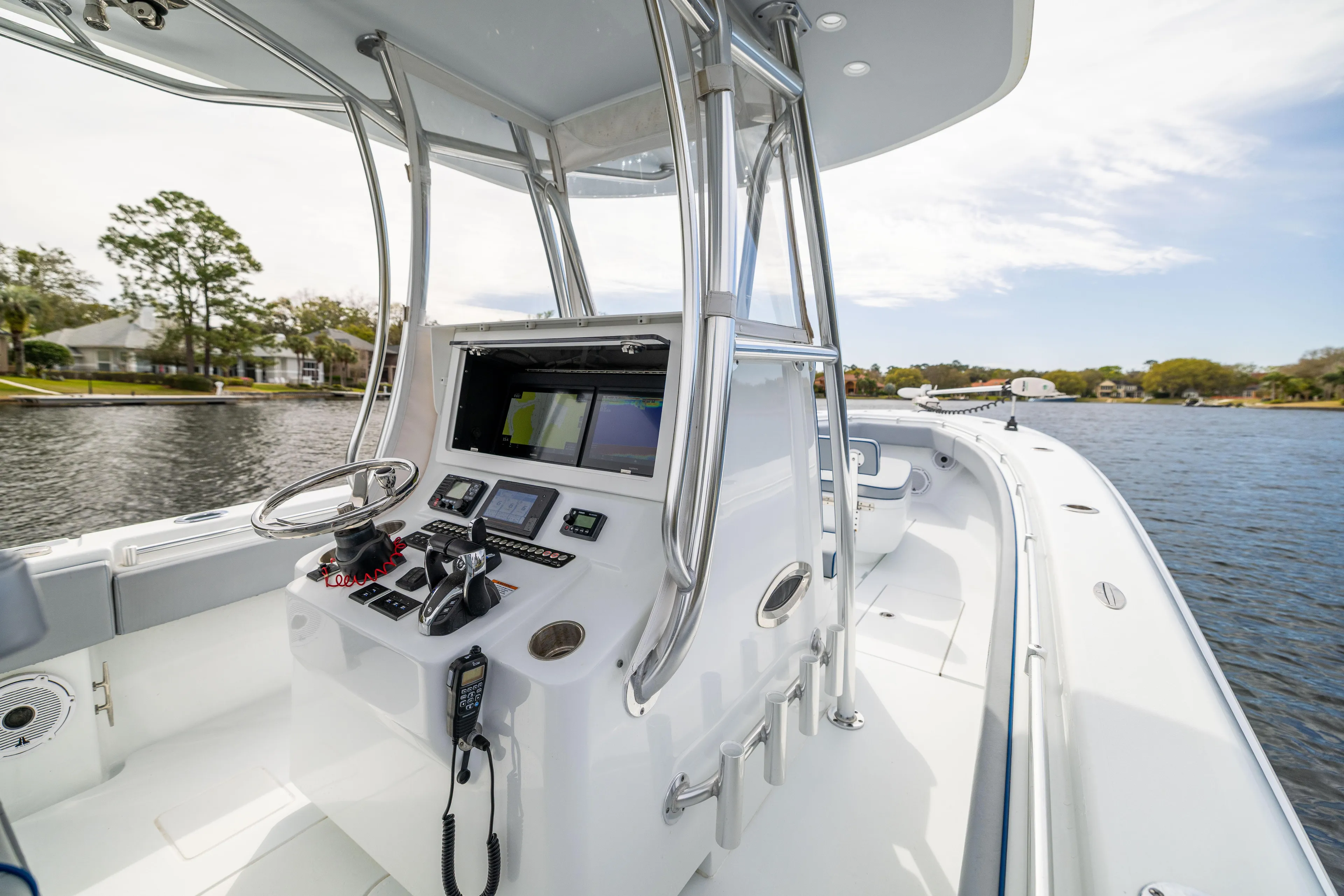 Yacht Photos Pics 2022 Contender 35 ST boat cockpit with modern controls on a calm waterway.