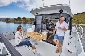  Yacht Photos Pics 2026 Jeanneau NC 1095 Coupe on water, people enjoying outdoor dining.