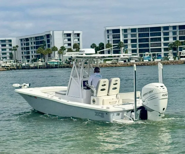  Yacht Photos Pics 2022 ZCB 26 Freemason boat cruising near modern waterfront buildings.