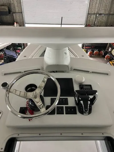  Yacht Photos Pics 2024 Contender 35 ST boat helm with steering wheel and controls in a garage setting.