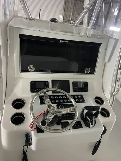  Yacht Photos Pics 2024 Contender 35 ST boat console with steering wheel and electronic controls.