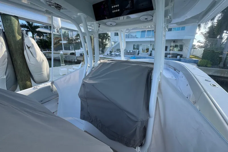 High Steaks Yacht Photos Pics 2024 Jupiter 38 HFS boat interior with covered console, docked near waterfront property.