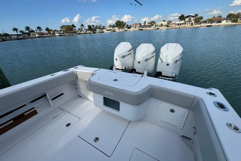 High Steaks Yacht Photos Pics 2024 Jupiter 38 HFS boat with triple outboard engines, docked by a scenic waterfront.